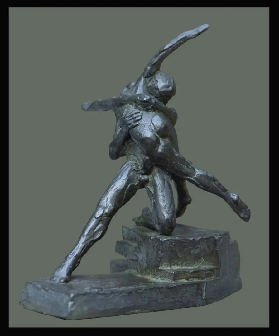 A bronze statue of a woman dancing on top of rocks.