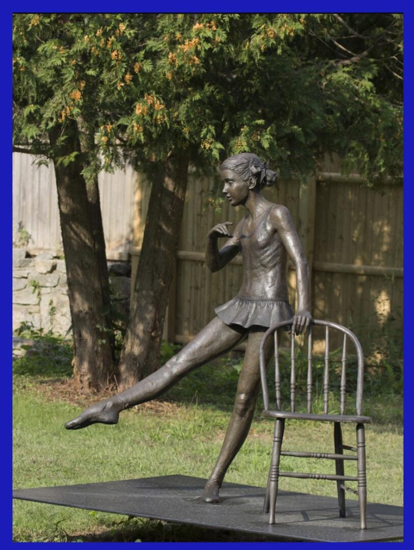 A statue of a girl in a skirt and a chair