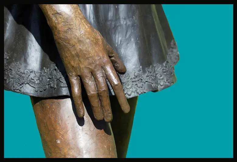 A close up of the hands and feet of a statue
