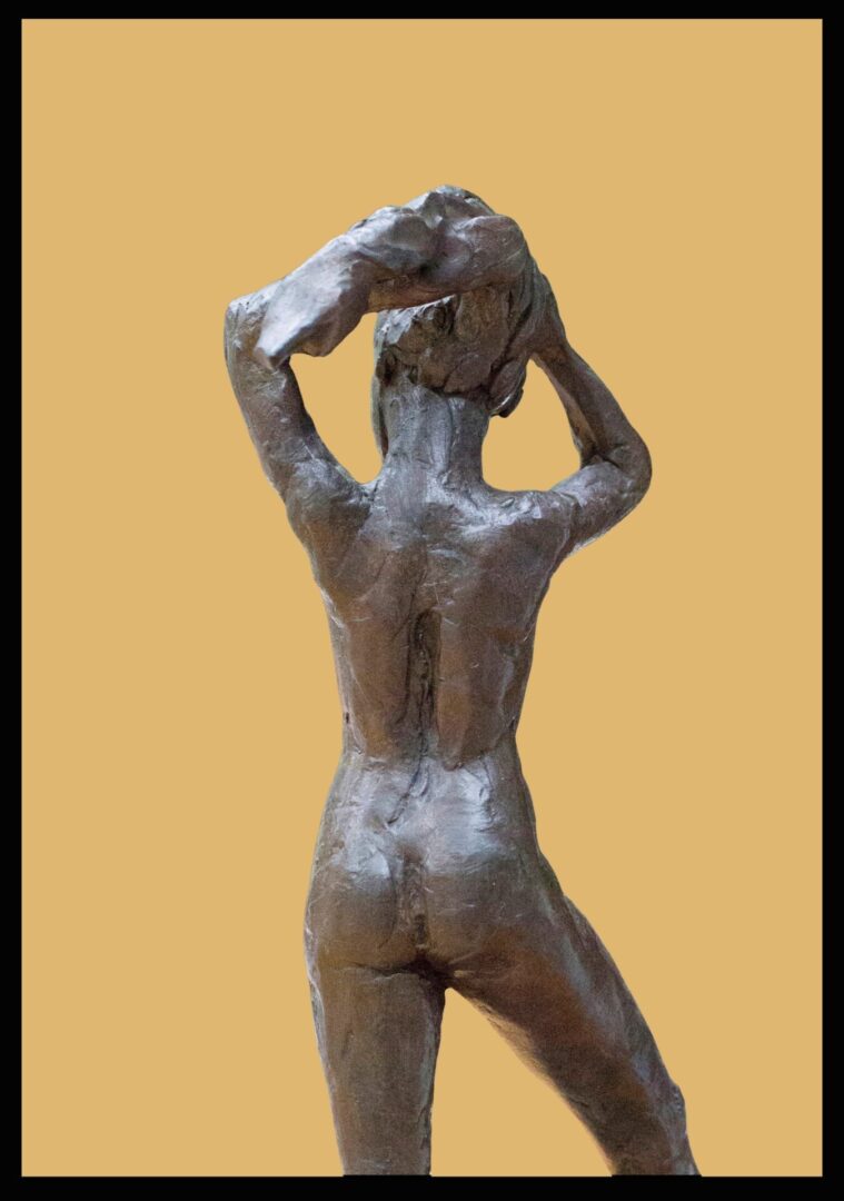 A sculpture of a naked man holding his head