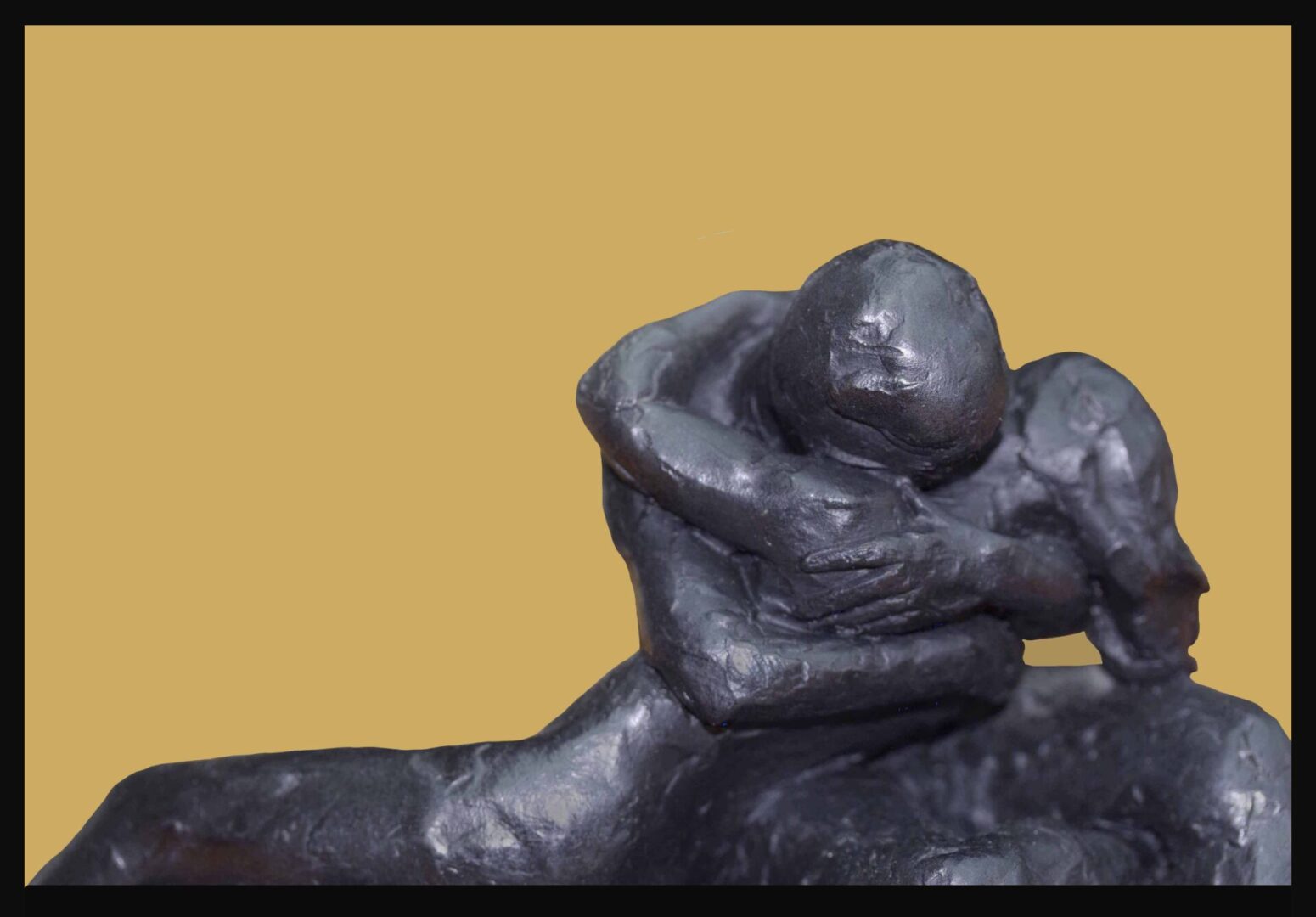 A sculpture of two people sitting on top of each other.